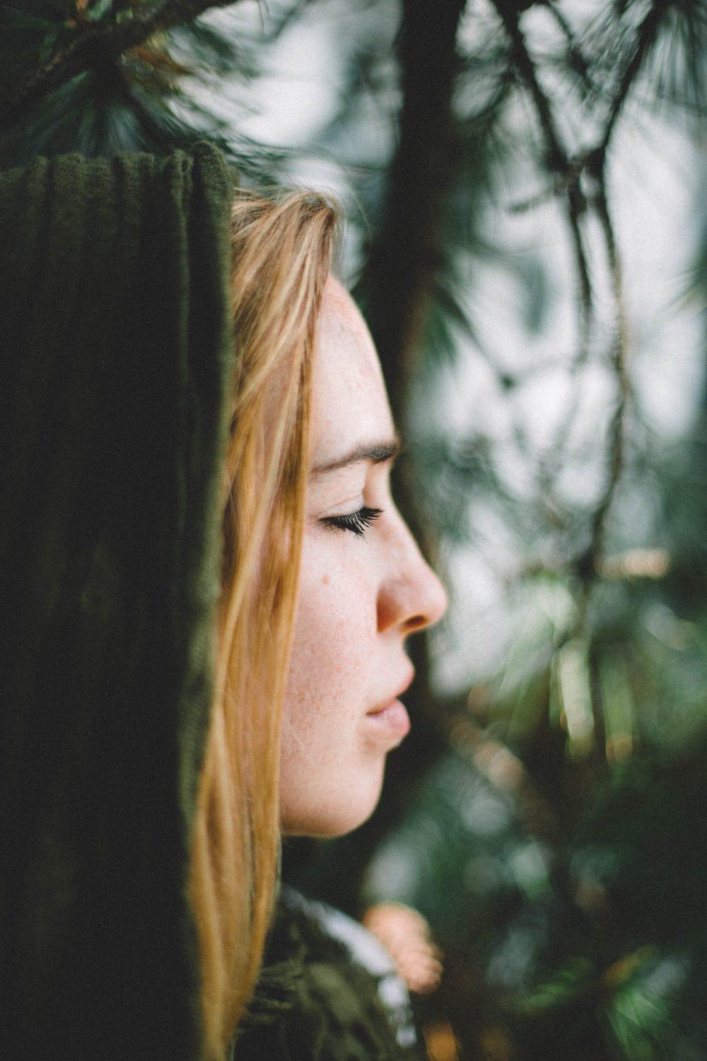 teen looking out into pine trees