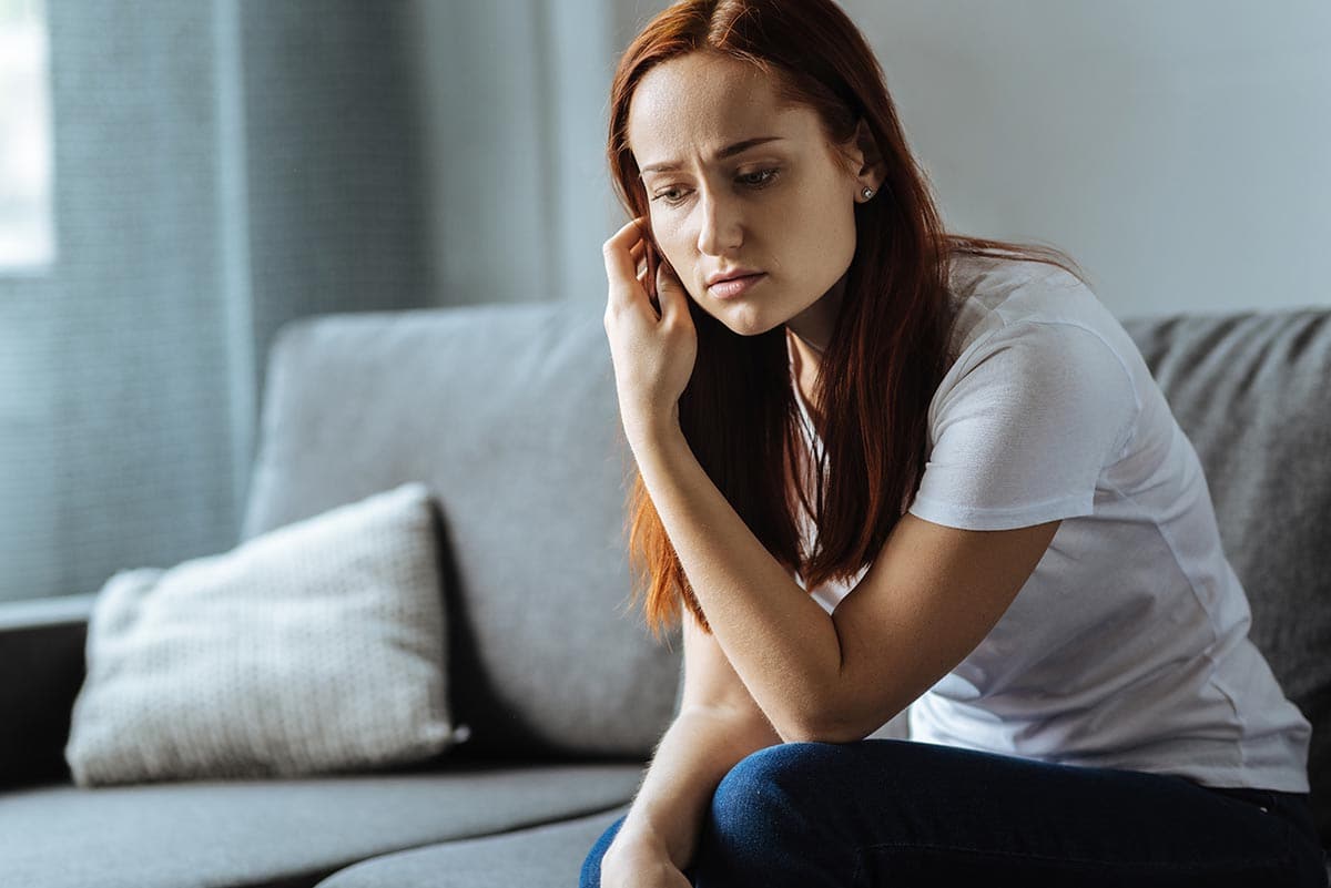 woman sitting down worried because she has depression and drug addiciton